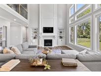 Bright living room features a fireplace, built-ins, and large windows with views of the landscaped lawn at 78 Chatham Brook Dr, Westfield, IN 46074