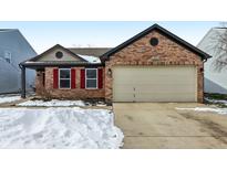 Brick ranch home with a two-car garage and snow-covered driveway at 14278 Holly Berry Cir, Fishers, IN 46038