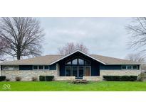 Charming single-story home with stone accents, large windows, and a well-maintained lawn at 2110 Round Barn Rd, Anderson, IN 46017