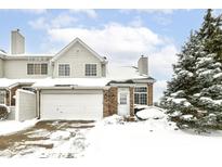 Two-story townhouse with brick and siding exterior, snow-covered landscaping, and attached garage at 5921 Bastille Ln, Indianapolis, IN 46254