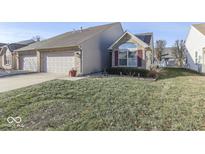 Tan two-story house with a two-car garage and a well-maintained lawn at 2814 Cadogan Dr, Greenwood, IN 46143