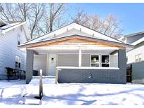 Newly painted craftsman home with covered porch and snow-covered yard at 330 Eastern Ave, Indianapolis, IN 46201