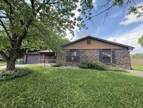 Charming brick home with a lush green lawn and mature tree providing shade at 3830 Pineview Ln, Greenwood, IN 46142