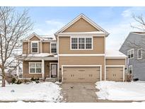 Two-story house with taupe siding, three-car garage, and snow-covered front yard at 5869 Gateway E Dr, Whitestown, IN 46075