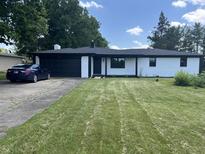 Charming white brick ranch home with dark trim, attached garage, and a well-manicured lawn at 6805 E County Road 100 S, Avon, IN 46123