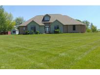 Charming brick home boasts a well-manicured lawn, creating a welcoming curb appeal at 7099 S 1100 W, Jamestown, IN 46147