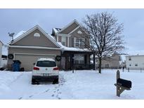 Two-story house with attached garage, covered porch, and snowy front yard at 9704 Gull Lake Dr, Indianapolis, IN 46239