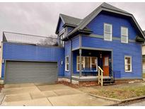 Stunning blue two-story home with gray accents, a detached garage, and a deck at 114 N Oriental St, Indianapolis, IN 46202