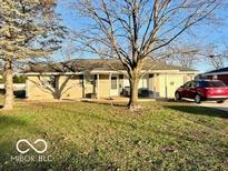 Ranch home with a large front yard and mature trees at 3429 Central Ave, Columbus, IN 47203