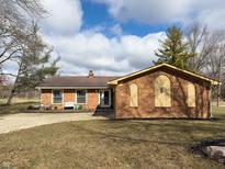 Attractive brick ranch featuring an attached garage, well-maintained landscaping, and a spacious driveway at 3699 Lisa Ln, Plainfield, IN 46168