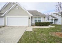 Beige house with white garage door and landscaping at 9004 Lisering Cir, Indianapolis, IN 46256