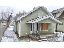 Green house with a front porch and small yard at 1218 N Ewing St, Indianapolis, IN 46201