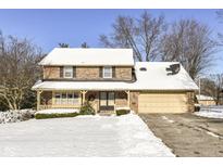 Brick house with attached garage, covered porch, and snowy yard at 3226 W 8Th St, Anderson, IN 46011