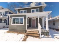 Charming two-story home featuring a covered front porch, gray siding, and a well-maintained lawn at 4014 N Capitol Ave, Indianapolis, IN 46208
