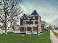 Charming two-story brick home featuring a covered porch and distinctive architectural details at 503 S Harrison St, Alexandria, IN 46001