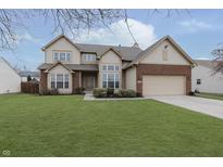 Two-story house with brick and siding, attached garage, and well-manicured lawn at 6023 Twyckenham Dr, Indianapolis, IN 46236