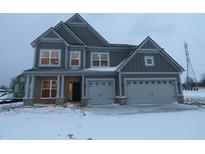 Two-story home with a two-car garage, gray siding, and a covered front porch during the winter season at 1123 Ridgevine Rd, Greenwood, IN 46143
