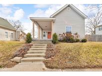 Charming home with a covered porch and inviting red door, complemented by a well-maintained front yard at 227 W South St, Greenfield, IN 46140