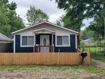Charming single-story home featuring a cozy front porch and a well-maintained lawn with wood fence at 2817 S Rybolt Ave, Indianapolis, IN 46241