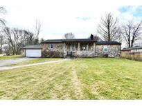 Stone ranch house with attached garage and spacious lawn at 3515 E 300 N, Anderson, IN 46012