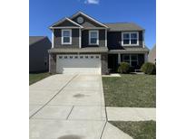 Charming two-story home featuring a spacious driveway, two-car garage, and well-maintained lawn under a clear blue sky at 6232 Emerald Springs Dr, Indianapolis, IN 46221