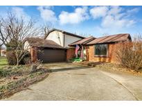 Brick ranch house with attached garage and large driveway at 704 Covered Bridge Rd, Greenwood, IN 46142