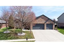 Lovely single-story brick home with an attached two-car garage and well-maintained lawn at 7709 Santolina Dr, Indianapolis, IN 46237