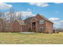 Elegant brick home featuring manicured landscaping and a spacious front lawn at 9263 Compton Farm Ln, Indianapolis, IN 46259
