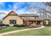 Charming two-story home with stone accents, lush landscaping, and a winding walkway, all under a bright, partly cloudy sky at 105 S Maxwell Ct, Zionsville, IN 46077