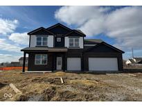 Two-story home with dark brick and vinyl siding, two-car garage, and covered porch at 241 Ames Dr, Whiteland, IN 46184