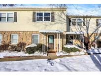 Two-story townhouse with stone and vinyl siding, snowy front yard at 2936 Country Estates Dr, Indianapolis, IN 46227
