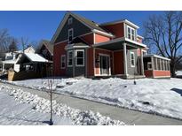 Two-story craftsman home with gray and coral siding, covered porch, and snowy yard at 359 N Jefferson St, Martinsville, IN 46151