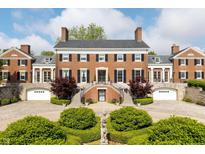 Stately red brick home featuring symmetrical design, manicured landscaping, and a welcoming front entrance with dual staircases at 4601 N Legacy Dr, Muncie, IN 47304