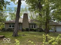 Charming one-story home featuring a stone chimney and a well-maintained front lawn with mature trees at 4621 E 37Th St, Indianapolis, IN 46218