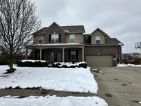 Two-story brick home with attached garage and snowy front yard at 5876 Sunnyvale Dr, Bargersville, IN 46106