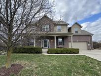 Charming two-story brick home featuring a covered porch and well-manicured landscaping at 5876 Sunnyvale Dr, Bargersville, IN 46106