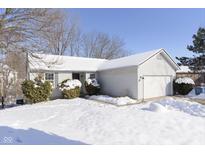 Ranch-style home with snow-covered lawn and attached garage at 6021 Prentis Cir, Indianapolis, IN 46254