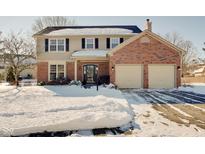 Brick two-story house with attached two-car garage and snowy front yard at 7891 Tufton Ct, Fishers, IN 46038