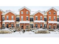 Brick townhouses with snow covered steps and landscaping at 1056 Reserve Way, Indianapolis, IN 46220