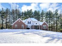 Brick two-story home with a snowy front yard and wooded backdrop at 125 Chalet Dr, Mooresville, IN 46158