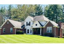 Charming two-story home with brick accents, a welcoming porch, and lush green lawn at 125 Chalet Dr, Mooresville, IN 46158