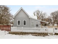 Gray sided house with white picket fence and snowy yard at 1430 St Paul St, Indianapolis, IN 46203