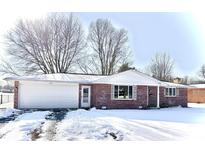 Brick ranch home with attached garage, snow-covered yard at 2919 E 8Th St, Anderson, IN 46012