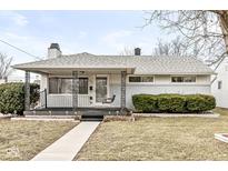Charming single-story home with a covered front porch and swing, landscaped with green bushes at 402 N 14Th Ave, Beech Grove, IN 46107