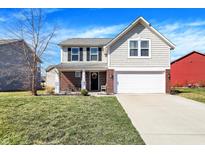 Charming two-story home with a blend of vinyl siding, brick accents, and a well-manicured front lawn at 5559 W Woods Edge Dr, McCordsville, IN 46055