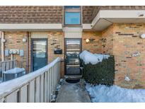 Brick townhouse exterior with snow-covered walkway and landscaping at 7421 Country Brook Dr, Indianapolis, IN 46260