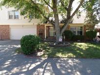 Ranch house with mature tree, landscaping, and a two-car garage at 7569 Farm View E Cir, Indianapolis, IN 46256