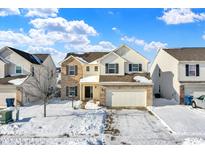 Two-story house with brick and siding, two-car garage, and snow-covered yard at 5632 Wild Horse Dr, Indianapolis, IN 46239