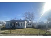 Charming single-story home featuring a cozy porch and well-maintained front yard, secured by a chain link fence at 5721 Shimer Ave, Indianapolis, IN 46219