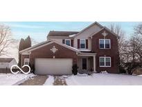 Brick two-story house with attached garage and snowy front yard at 6663 Trailside Dr, Avon, IN 46123